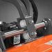 close-up of metal roller bracket and pivot assembly with oil warning label on orange MechMaxx 63-inch PTO flail mower gallery 1