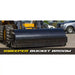 Black loader attachment with wide steel bucket broom and hydraulic connections visible on paved surface