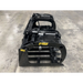 Black metal skid steer grapple attachment with hydraulic cylinders, curved tines, and reinforced frame on concrete floor