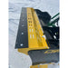 Yellow and black compact snow pusher attachment mounted on green skid steer loader arm in snowy setting