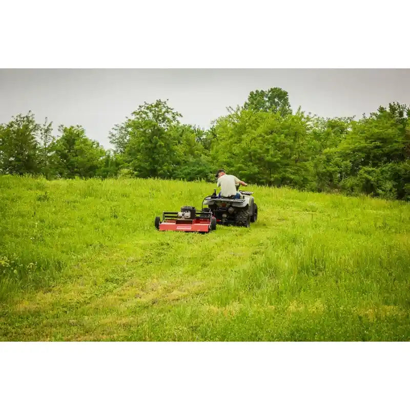 Rear view of Swisher 44" Rough Cut Brush Mower being towed by ATV across dense grass, gallery position 1