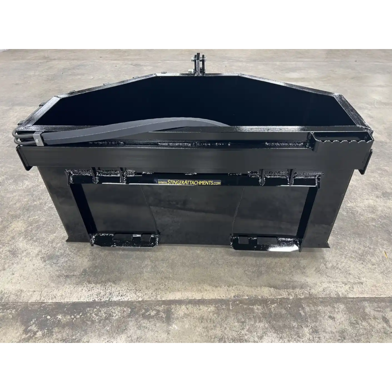 Black skid steer attachment with reinforced edges and mounting brackets on a concrete floor surface