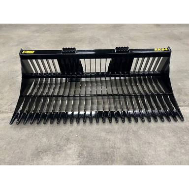 Front view of black metal skid steer rock bucket with closely spaced tines and reinforced mounting brackets on concrete floor