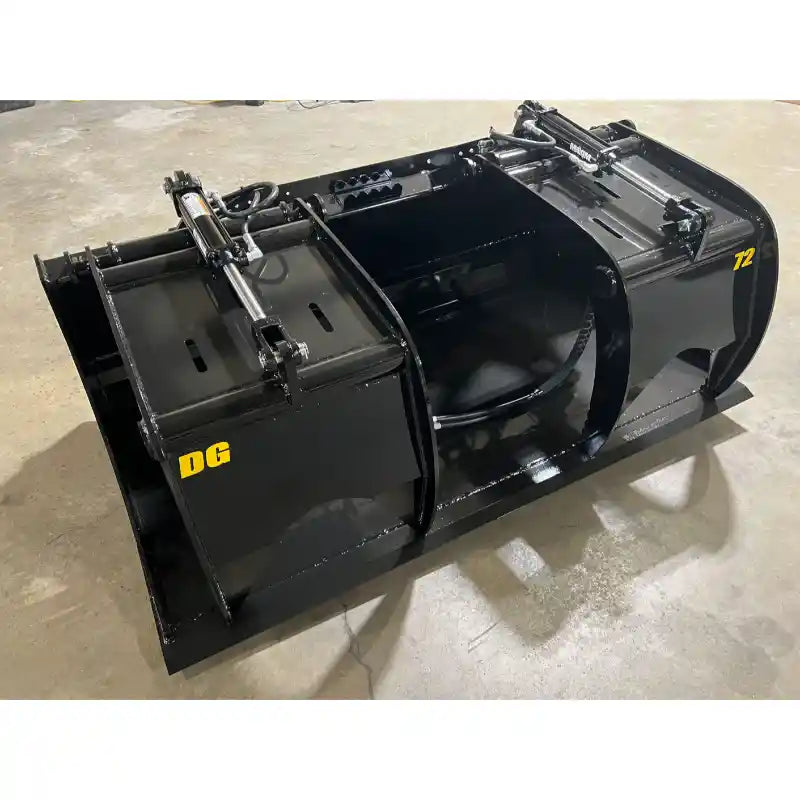 Black steel hydraulic grapple bucket attachment with dual cylinders and curved clamp arms on indoor concrete floor