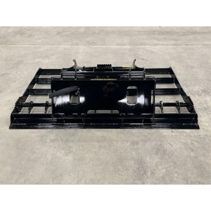 Front view of black painted steel skid steer land plane attachment with mounting plate on concrete floor
