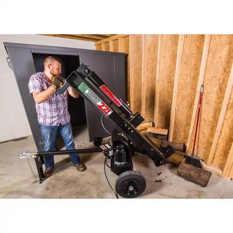 Man adjusting Swisher 22-Ton Timber Brute Eco Split electric log splitter inside unfinished wood-framed storage room, gallery 1