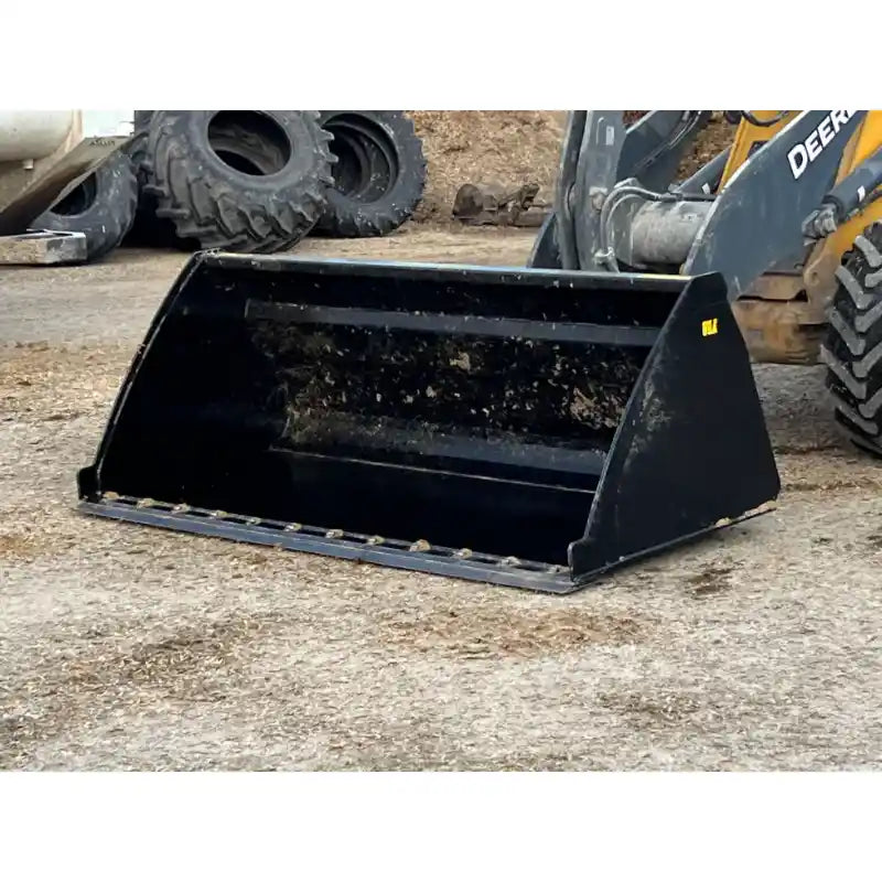 Front-left view of black steel skid steer bucket attachment resting on gravel at outdoor equipment yard
