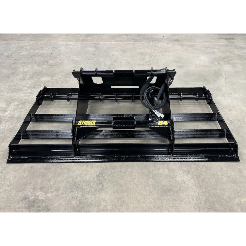 Front view of black steel skid steer land plane attachment with mounting frame and hydraulic hose on concrete floor
