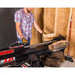 Operator placing log on Swisher 22-Ton Timber Brute Eco Split electric log splitter inside wood-framed shed, gallery position 1