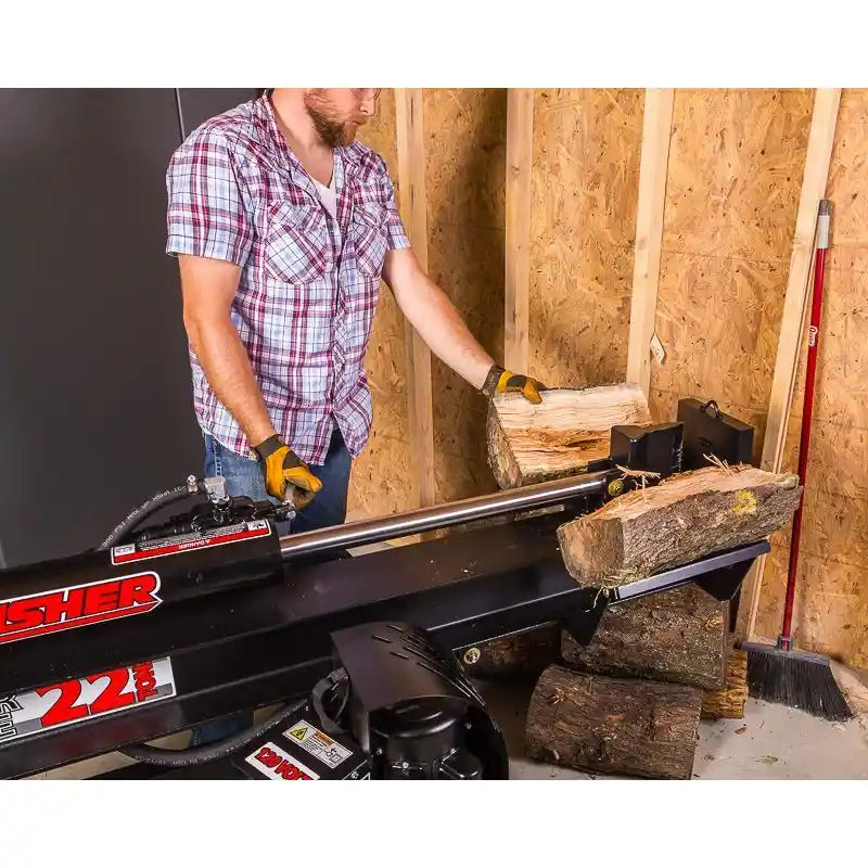 Operator placing log on Swisher 22-Ton Timber Brute Eco Split electric log splitter inside wood-framed shed, gallery position 1