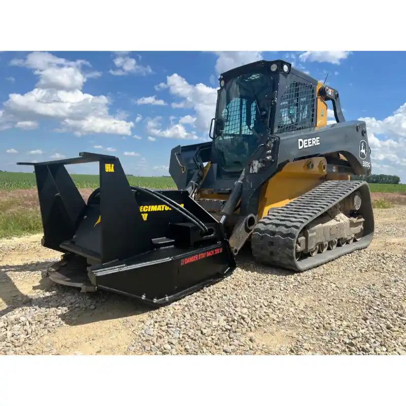 Tracked skid steer with black disc mulcher attachment on gravel surface under blue sky