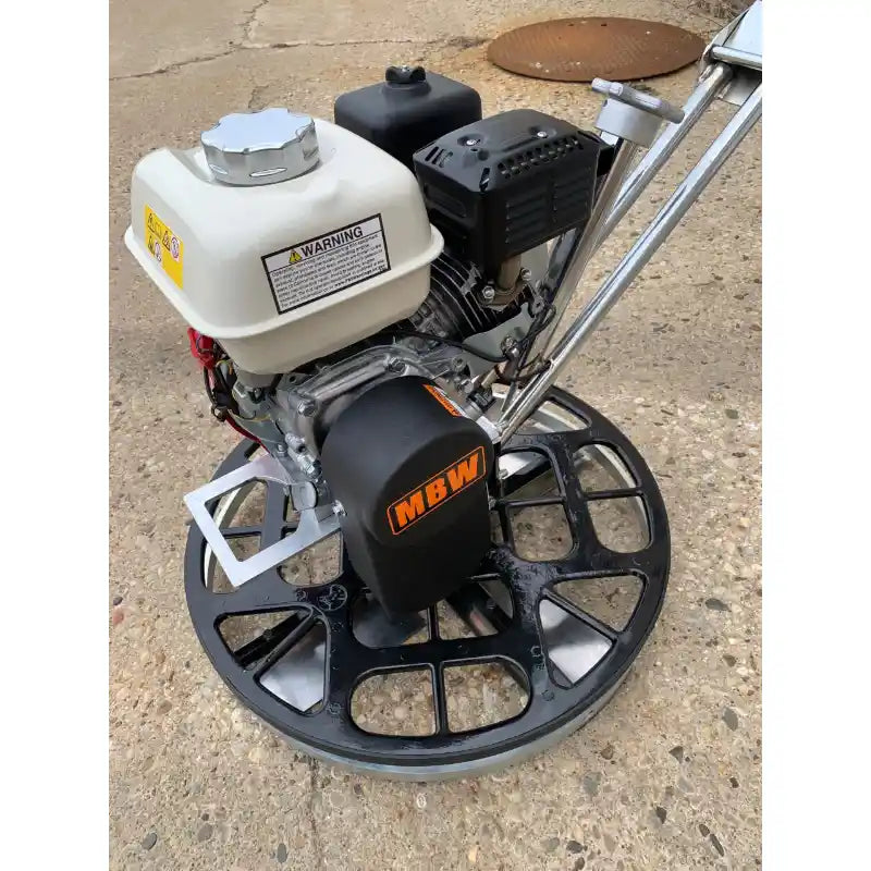 Walk-behind power trowel with white fuel tank, black engine cover, and metal handlebar on concrete surface