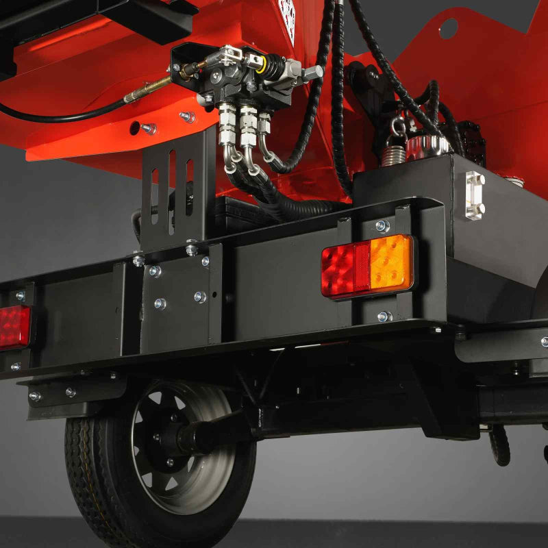 Close-up of rear trailer lights, axle, and hydraulic hose connections on MechMaxx 7-inch wood chipper, gallery position 1