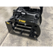 Black skid steer grapple attachment with spaced steel tines, hydraulic cylinder, and welded frame on concrete floor