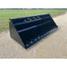 Large black steel snow bucket attachment with vent slots and bolt-on cutting edge on gravel surface