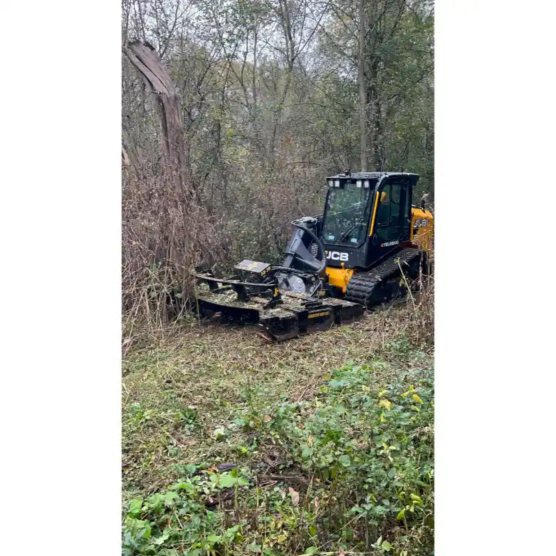 JCB skid steer with Stinger Attachments TF3 Twister brush cutter clearing overgrown brush in woodland area, square image 800x800.