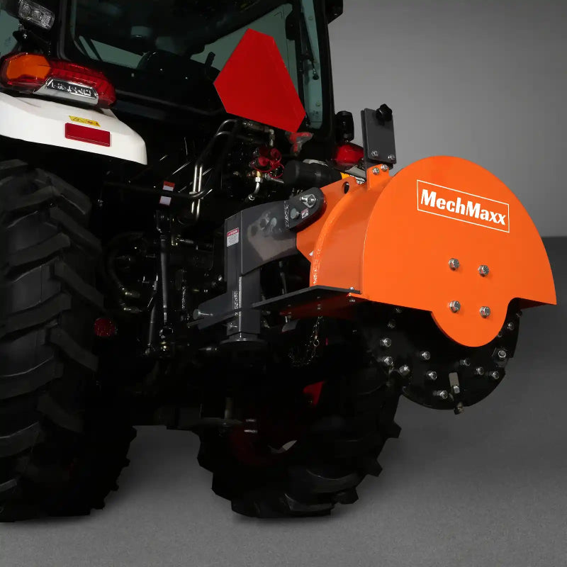 rear angled view of orange MechMaxx SG24 3-point PTO stump grinder attached to tractor, gallery position 1