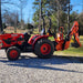 side view of red Branson tractor with orange MechMaxx BH660 7-foot backhoe attachment at gallery position 1