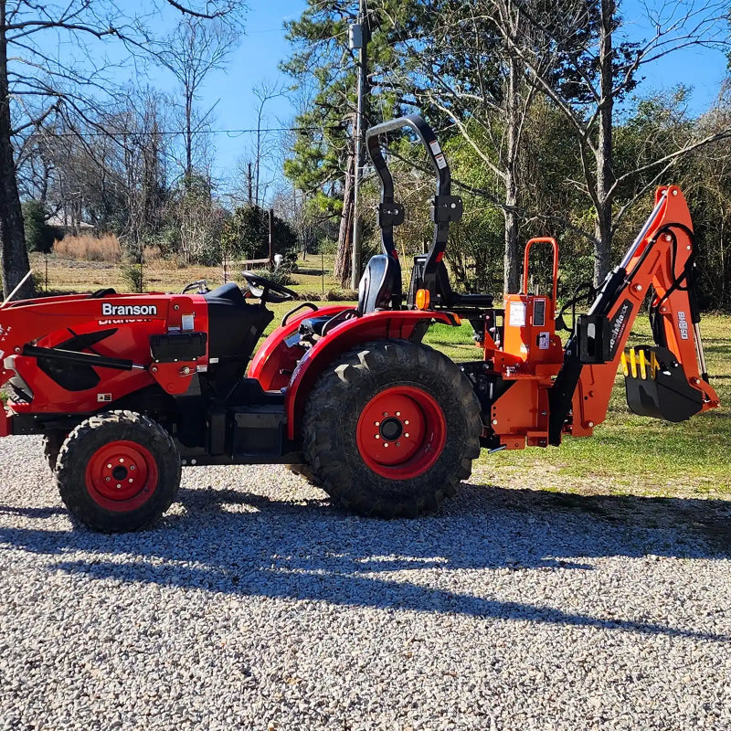 side view of red Branson tractor with orange MechMaxx BH660 7-foot backhoe attachment at gallery position 1