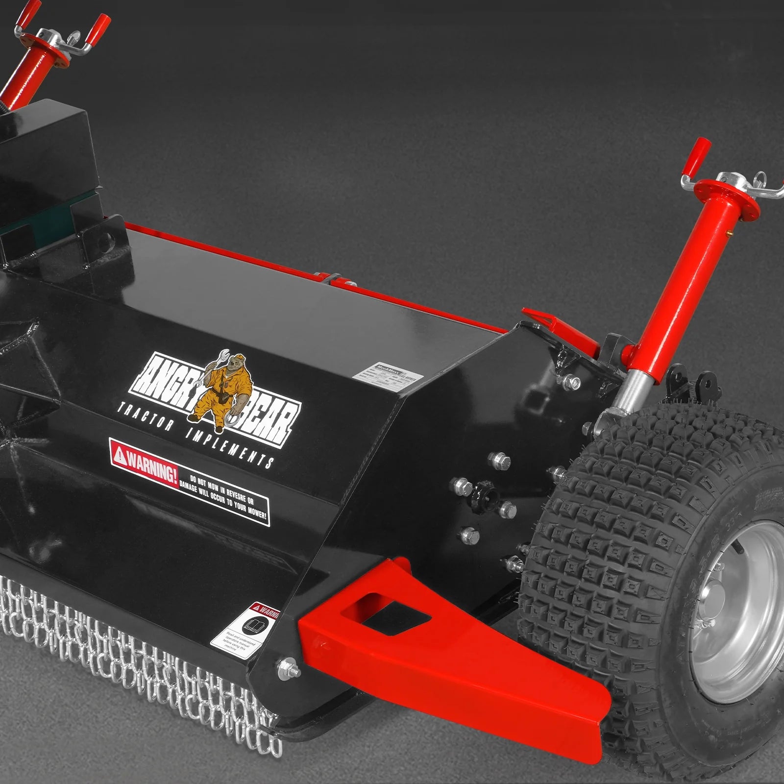 Black brush cutter attachment with red adjustment handles, treaded wheel, chain guard, and cutting deck