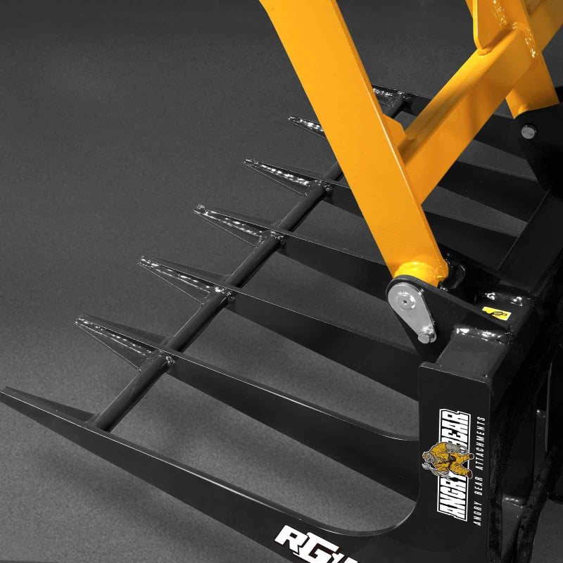close-up angled view of yellow mini skid steer skeleton grapple tines and arm with King Bear logo at gallery position 1