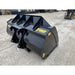 Angled front-left view of black steel construction material bucket with yellow Stinger branding on gravel surface