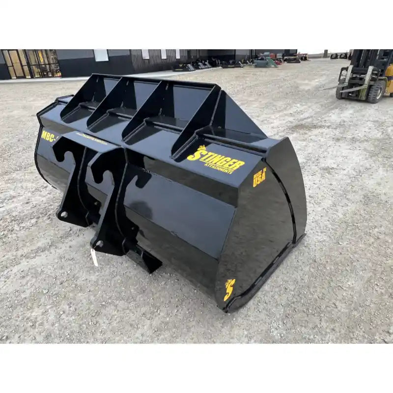 Angled front-left view of black steel construction material bucket with yellow Stinger branding on gravel surface