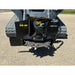 Stump grinder attachment with steel cutting wheel, multiple teeth, hydraulic hoses, and black mounting plate on compact tracked machine