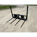 Four-prong black metal attachment for lifting or moving materials on gravel ground outdoors