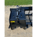 Black skid steer root grapple bucket with hydraulic cylinder and mounting bracket on gravel surface