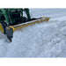 Yellow and black steel snow pusher attachment mounted on green tractor clearing deep snow on flat snowy surface