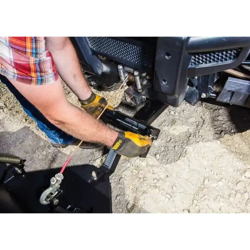Person wearing gloves connecting mounting bracket of Swisher 62-inch UTV plow to front receiver hitch, gallery position 1