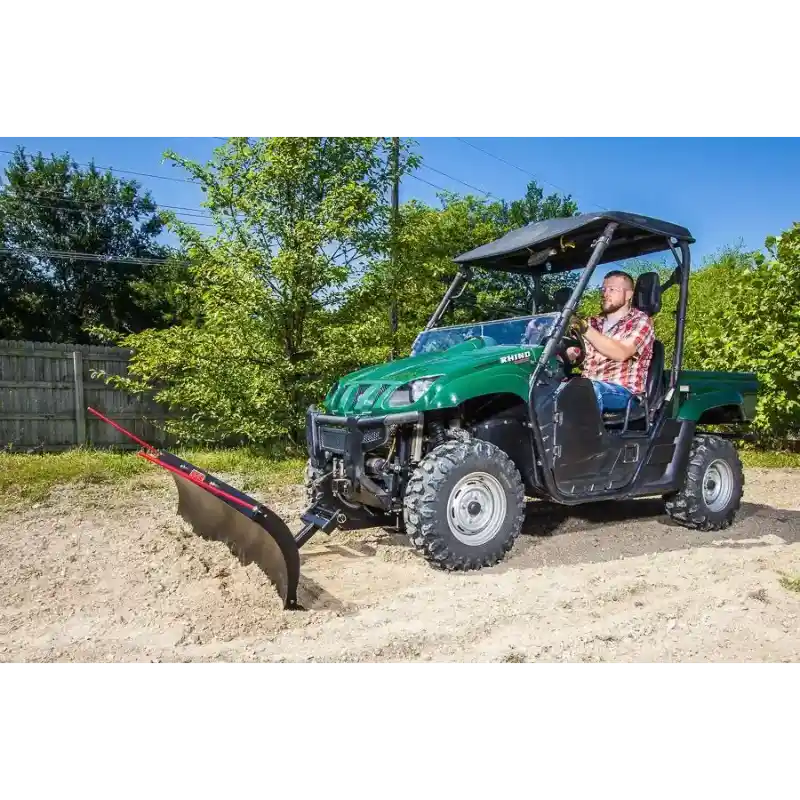 Green UTV equipped with 62-inch Swisher angle plow pushing soil, fitted with red guide rods, gallery position 1
