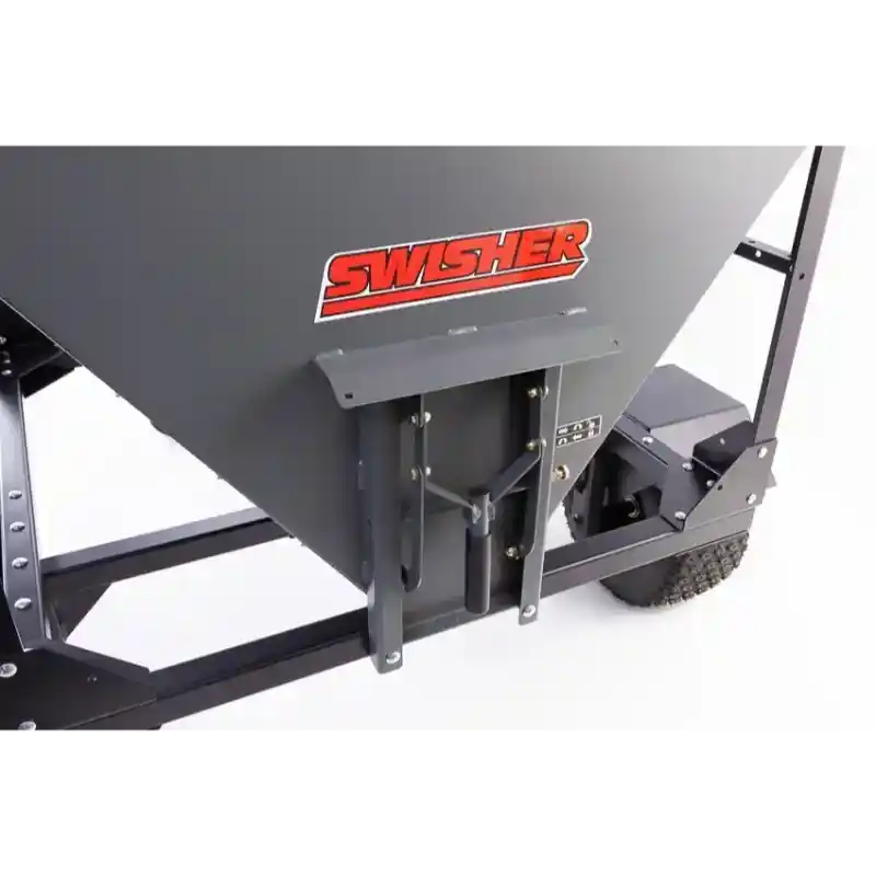 Close-up of gray metal discharge gate and Swisher logo on drop feeder, framed by steel chassis and tire, gallery position 1