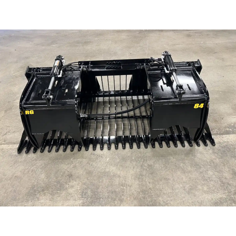 Black skid steer rock grapple attachment with dual hydraulic cylinders, wide serrated tines, and reinforced arms on concrete floor