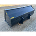 Back-left angled view of black steel material bucket attachment with smooth sides and yellow model markings on gravel ground