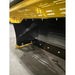 Close-up of yellow and black steel snow pusher attachment showing wear strip and mounting bolts on concrete floor