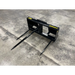 Black metal skid steer attachment with three pointed tines on a concrete floor, labeled Series 1