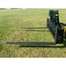 Black steel pallet fork attachment with solid rectangular backrest and two long fork tines on grass field outdoors