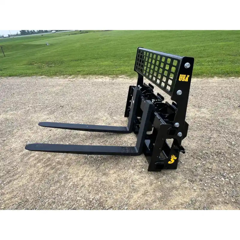 Black skid steer pallet fork attachment with perforated backrest and two straight extended forks on gravel surface