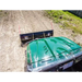 Overhead view of green utility vehicle fitted with Swisher 62-inch plow rolled blade on soil surface, gallery position 1