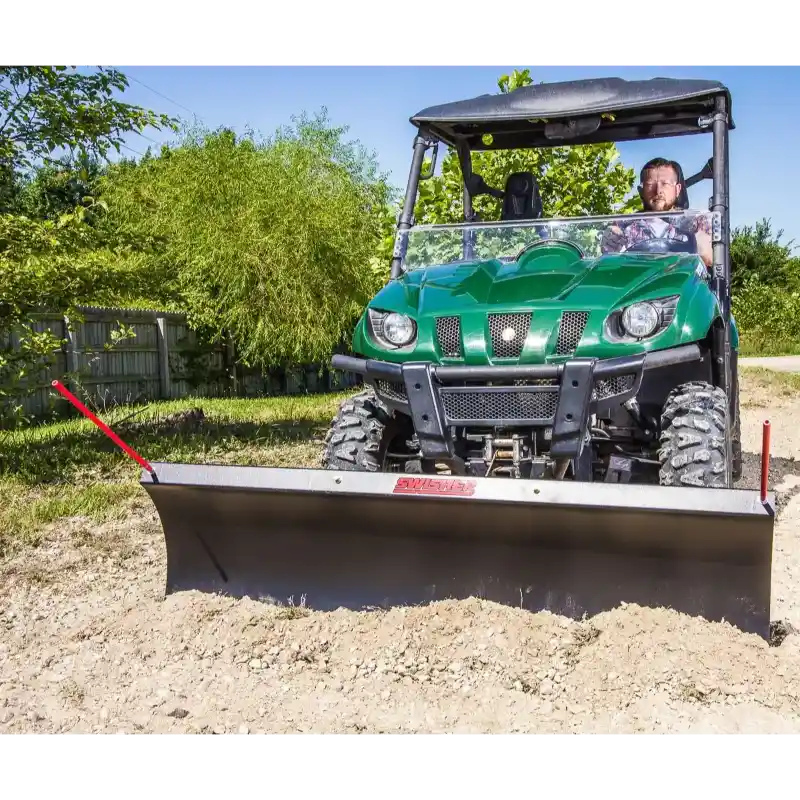 Green utility vehicle with Swisher 62-inch plow rolled blade attached pushing soil, gallery position 1