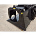 Black steel demolition grapple bucket attachment with hydraulic clamping arms resting on gravel surface outdoors