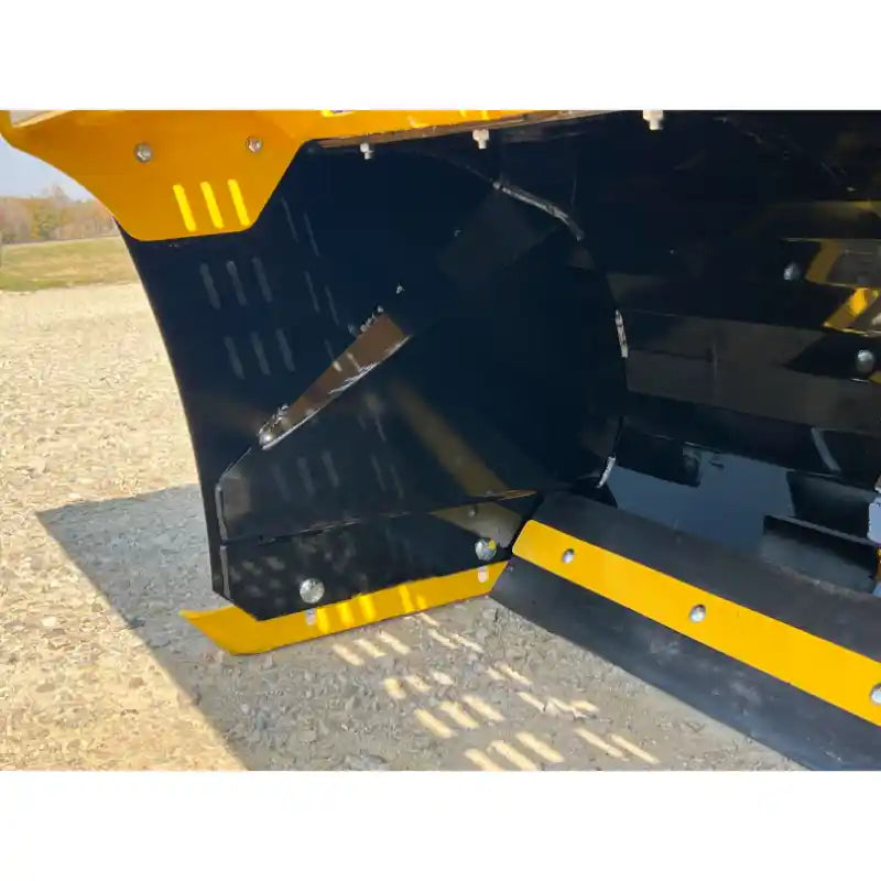Close-up of black and yellow metal skid steer snow pusher foot blade with bolt-on cutting edge on gravel surface