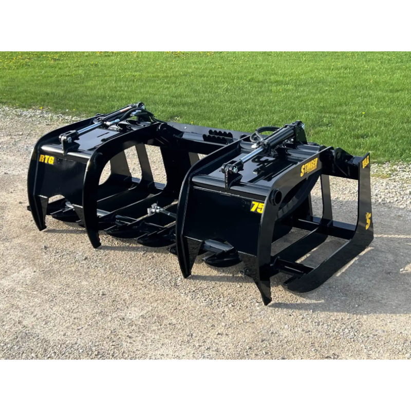 Black skid steer root grapple attachment with dual hydraulic arms and spaced curved tines on gravel and grass background