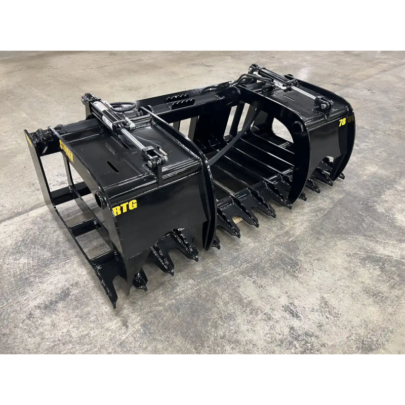Black steel skid steer grapple attachment with hydraulic cylinders, reinforced tines, and a solid frame on concrete floor