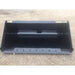 Front view of black skid steer material bucket with reinforced cutting edge and smooth interior resting on dirt surface