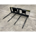 Four-tine black metal skid steer attachment for moving hay bales or large materials on concrete floor