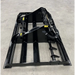 Black steel skid steer land plane attachment with hydraulic cylinders and hoses on concrete floor surface