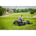 Operator riding ATV towing Swisher 44-inch rough cut mower cutting tall grass in residential area, gallery position 1